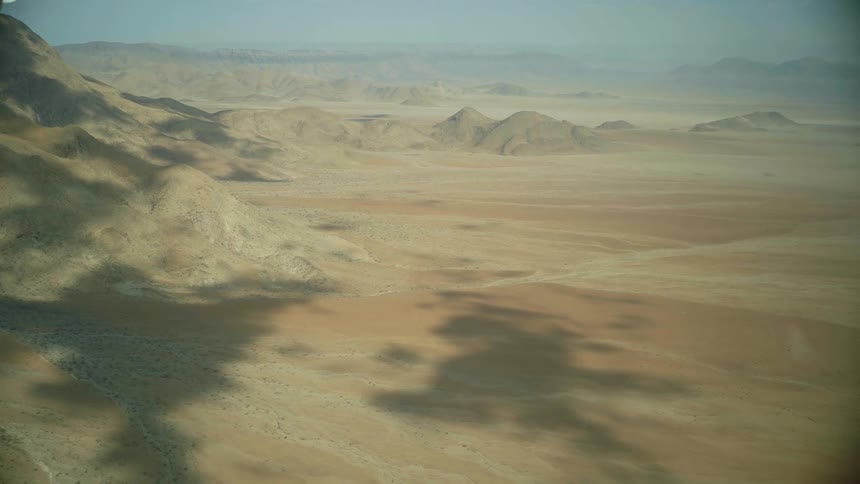 Aerial view of the shadow of clouds over the mountains on the desert