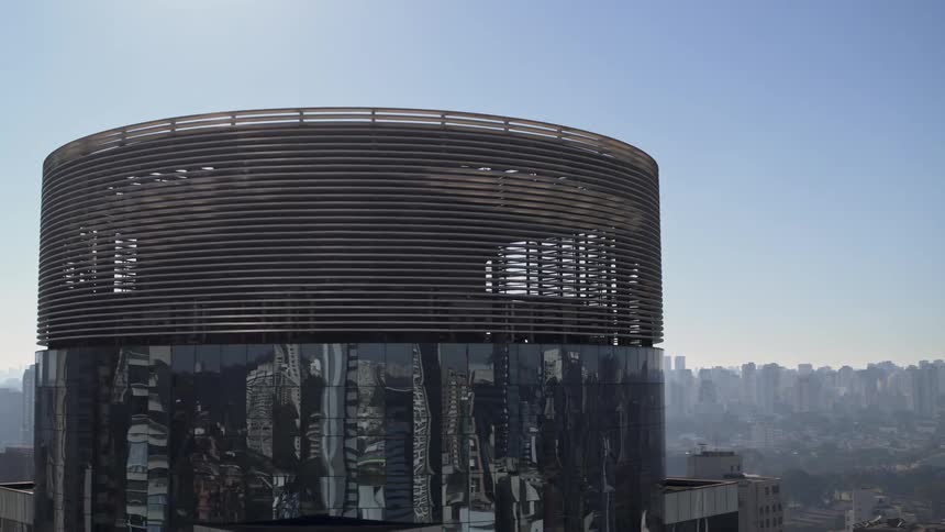 The top of a round skyscraper in a metropolis on a clear day