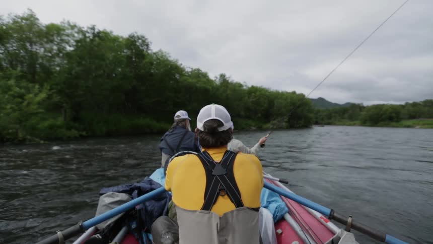 People are in a canoe fishing one is paddling