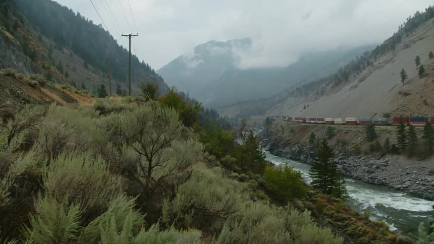 A stream is flowing in a mountain valley with a mountain in the distance