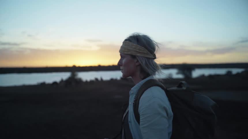 A woman standing outdoors holding a camera