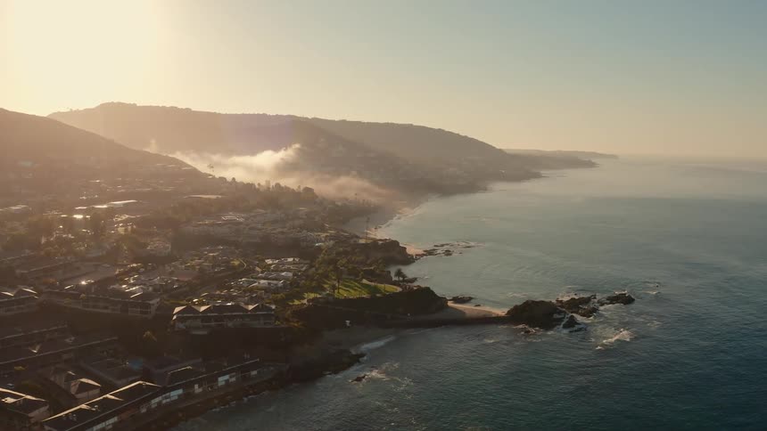 An aerial view of a coastal town and coastline at sunrise