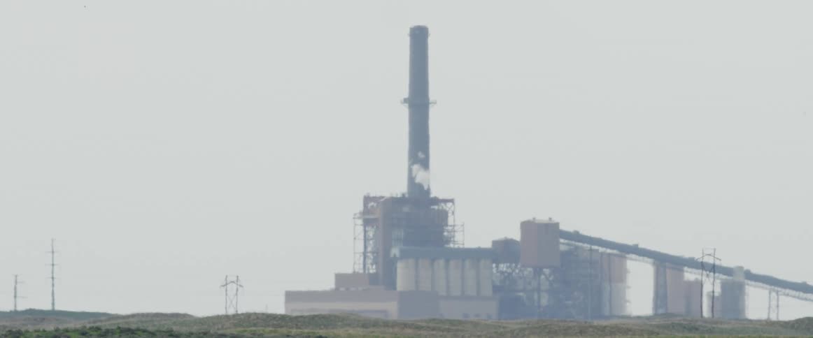 A large power plant is in the distance