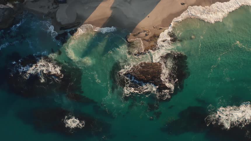 Waves crashing over rocks on a rugged beach