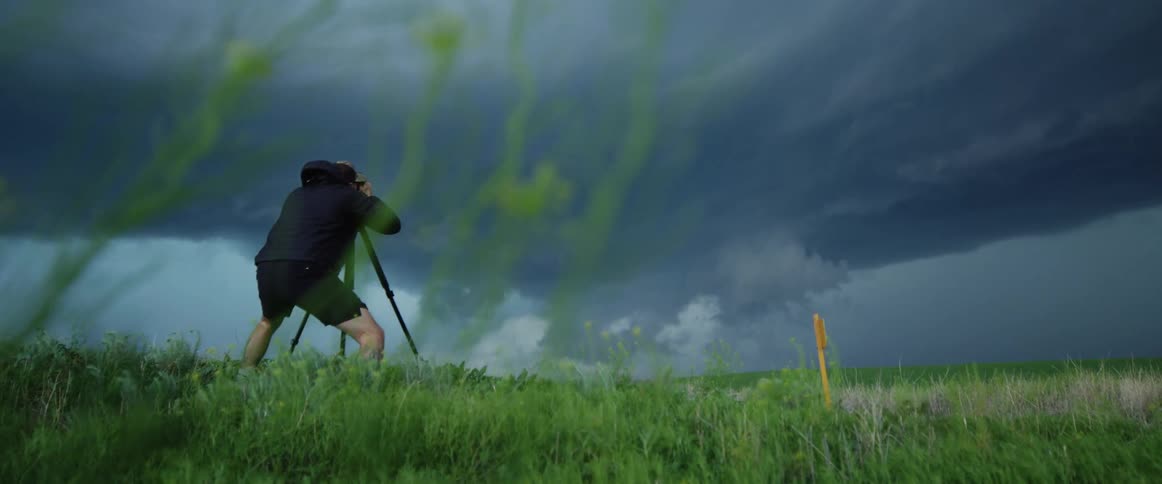 A man is taking photos of a storm