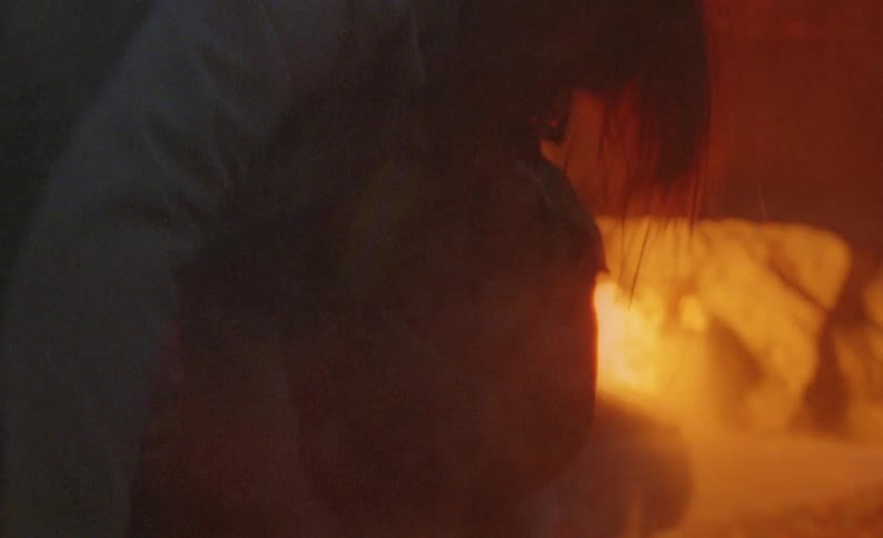 A house is on fire and fire fighters are hosing down the flames with water and rescue a woman