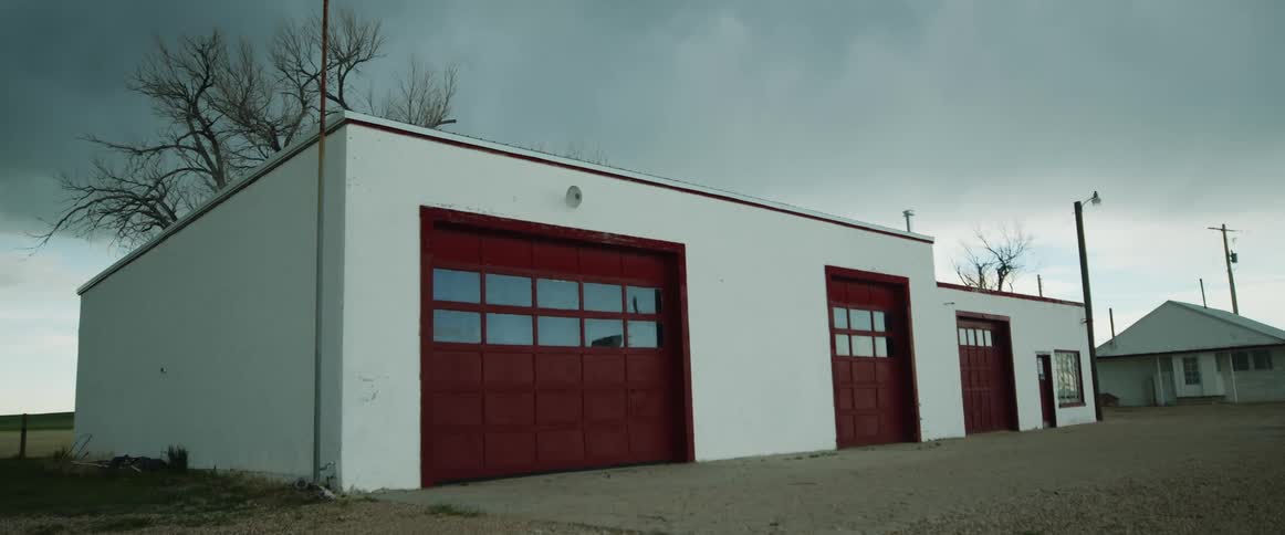 An auto garage with red doors is closed
