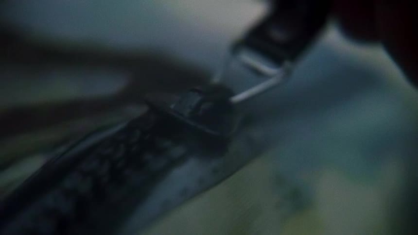A person pulls the zipper on a bag