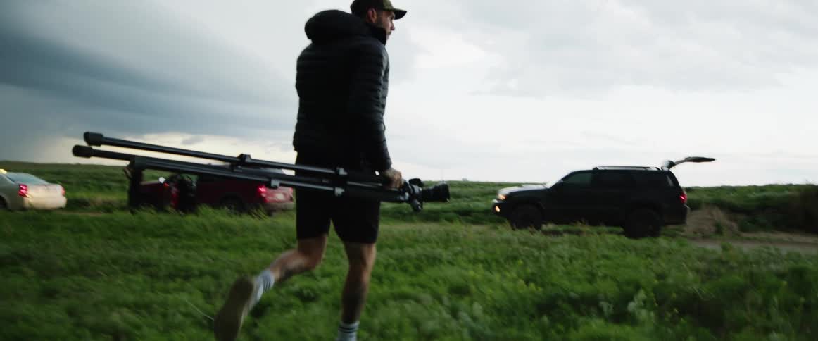 A man races with his camera to his vehicle