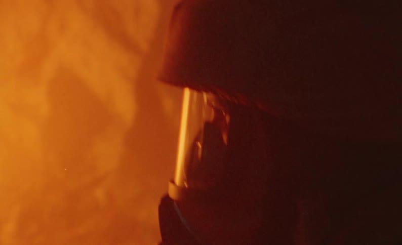 Firefighter extinguishing a car on fire at night