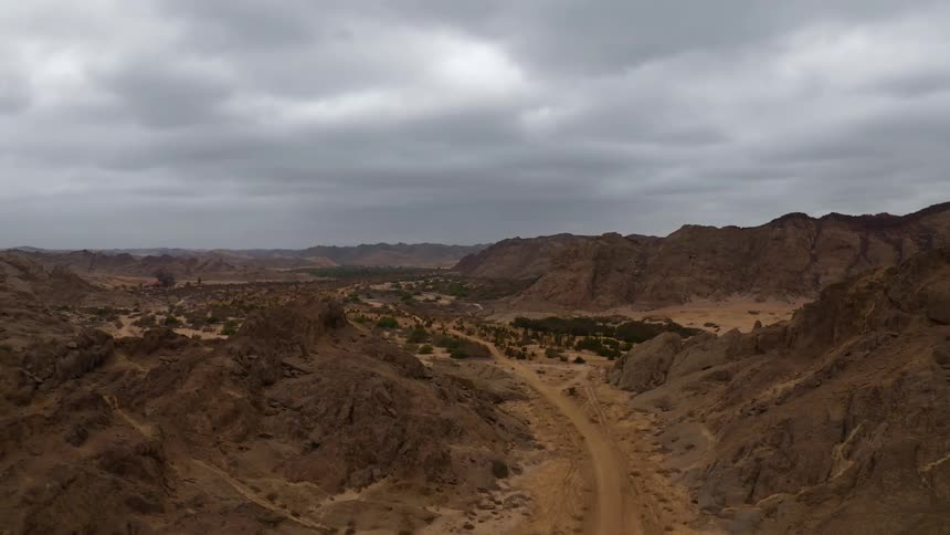 The canyon has a dirt trail through the middle