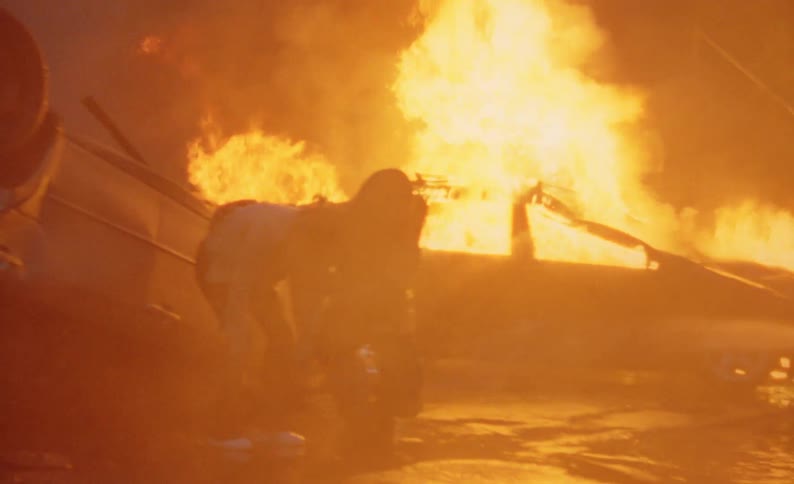 A firefighter carries a woman from a crash