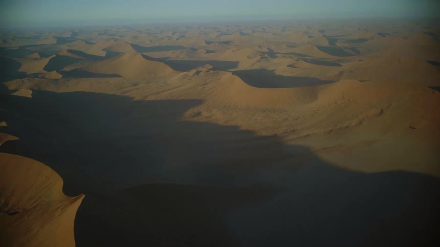 Vast sand dune hills in the desert on a hazy day