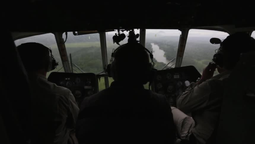 Three people sit in a aircraft cockpit