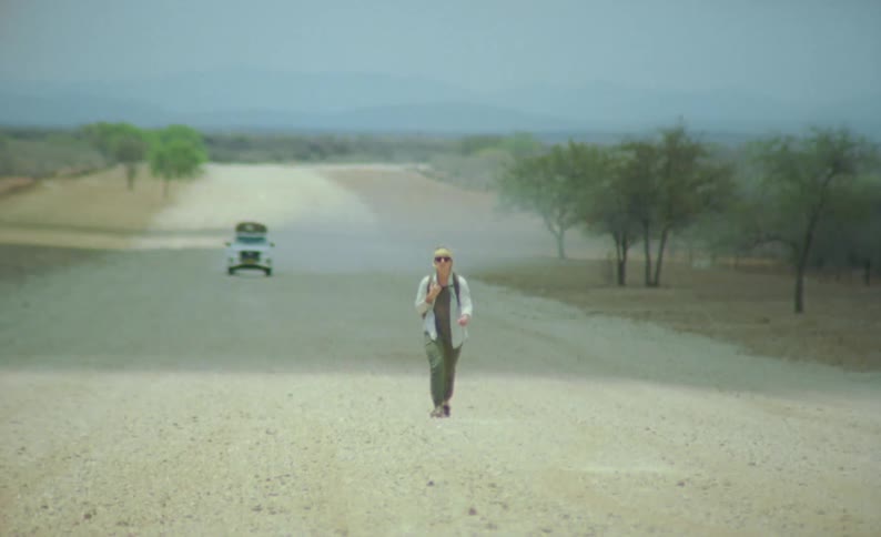 A woman walking down a dirt road