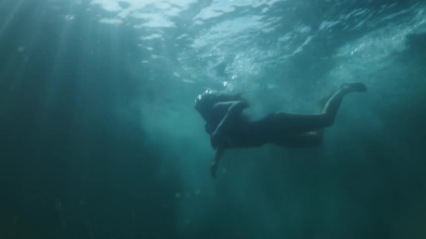 A woman is swimming in a body of water