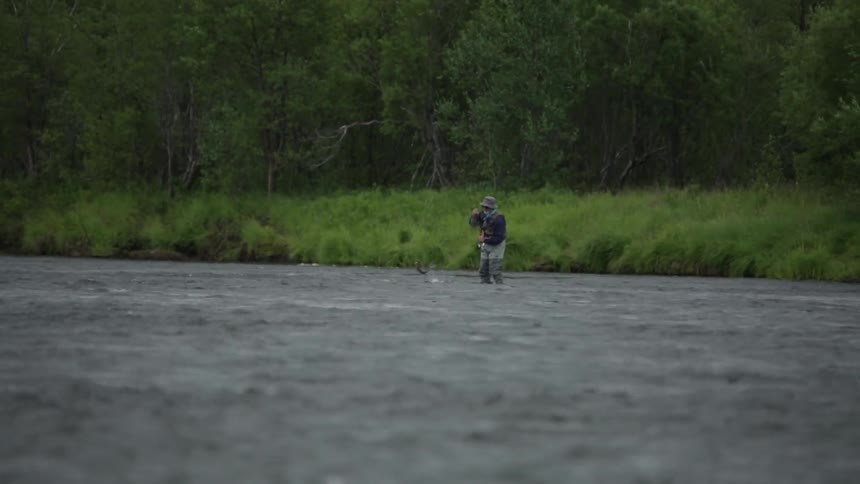 A man has caught a fish on his line