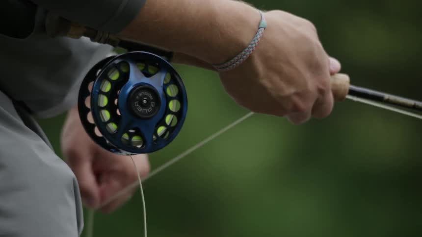 Close up of a person pulling the line in on his fishing pole