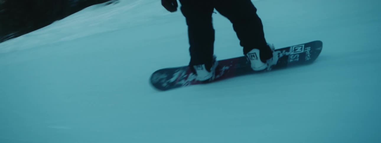 A person snowboarding outdoors on a mountain