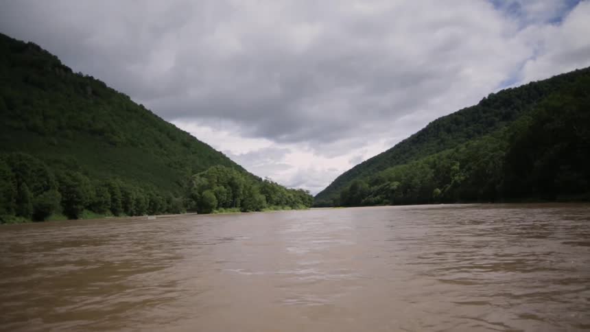 A body of water sits before two green hills