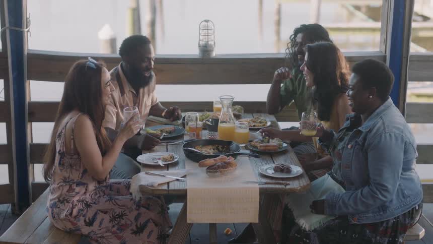 A group of people sitting around at a restaurant talking