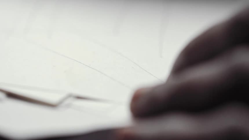 A person is drawing lines on paper using a pencil