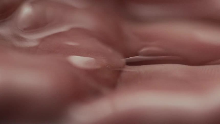 A very close view of a human hand being lifted from underneath water