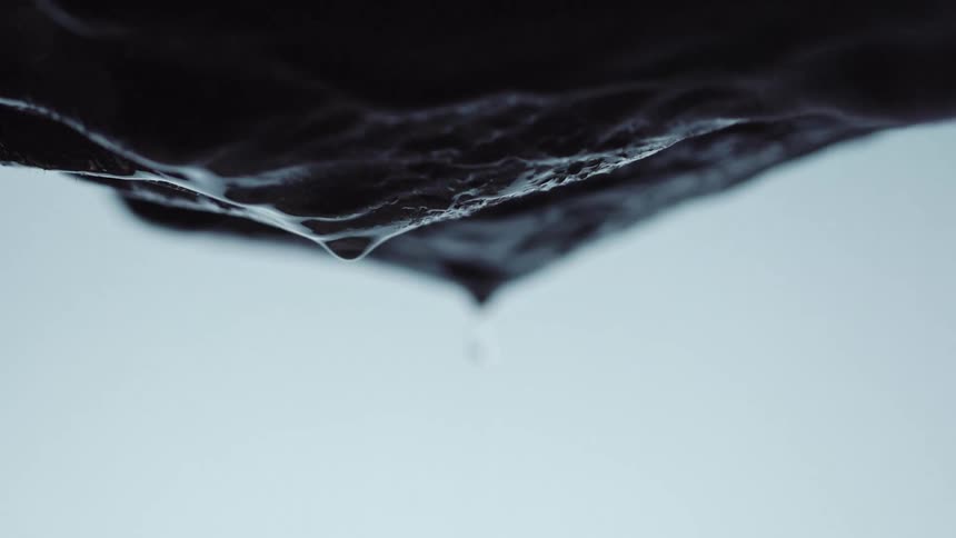 Water dripping from a persons hands with a white background