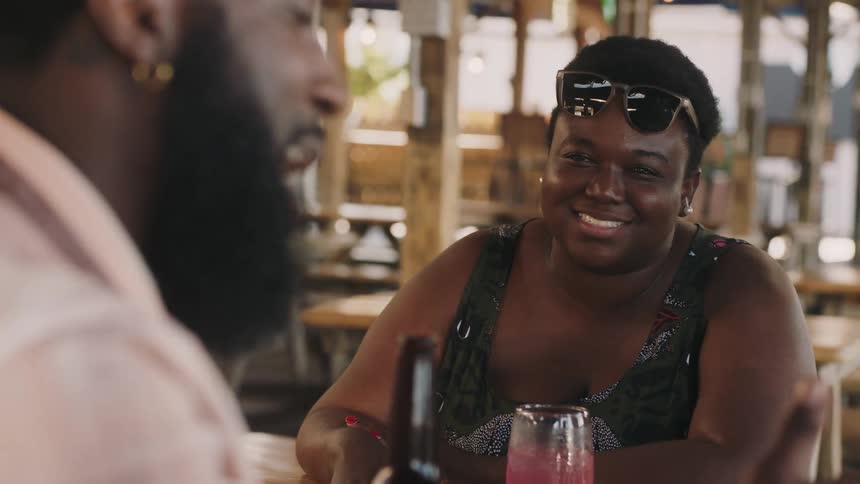A man and woman have drinks and talk in the bar