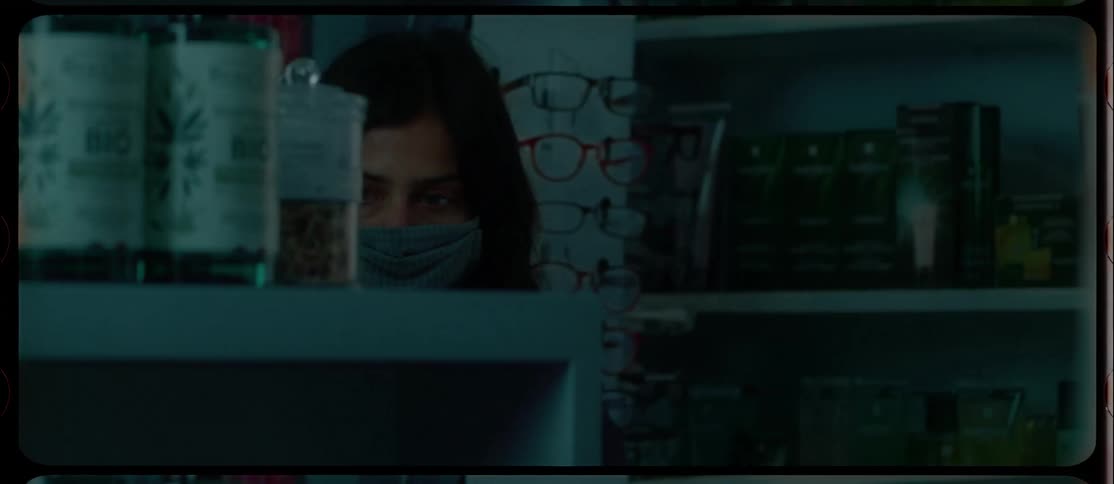 Woman adjusts face mask as she enters stores through automatic doors before browsing shelves