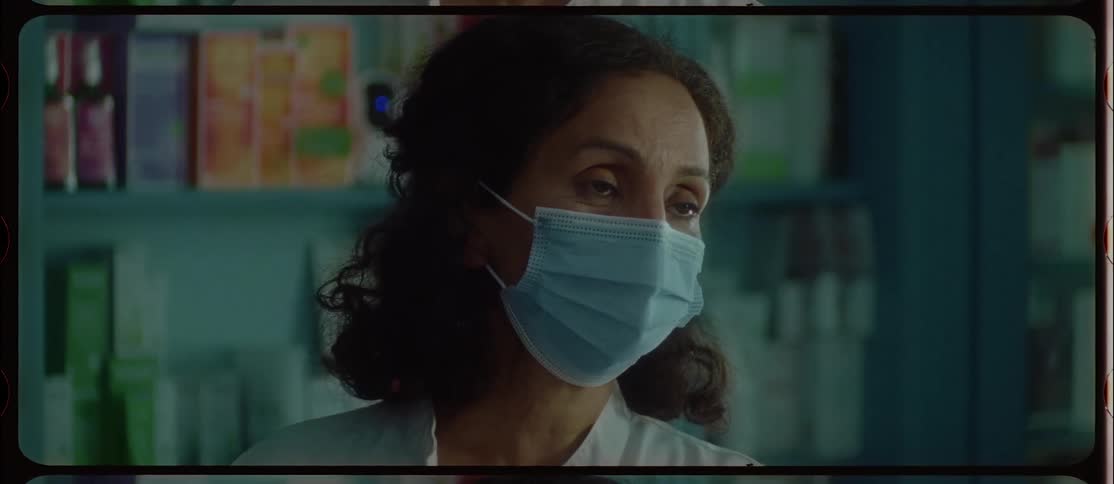Store clerk wearing face mask talks to customer showing them small tube