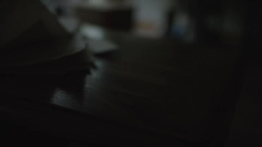 Pages on a table blow in the wind in a dark room