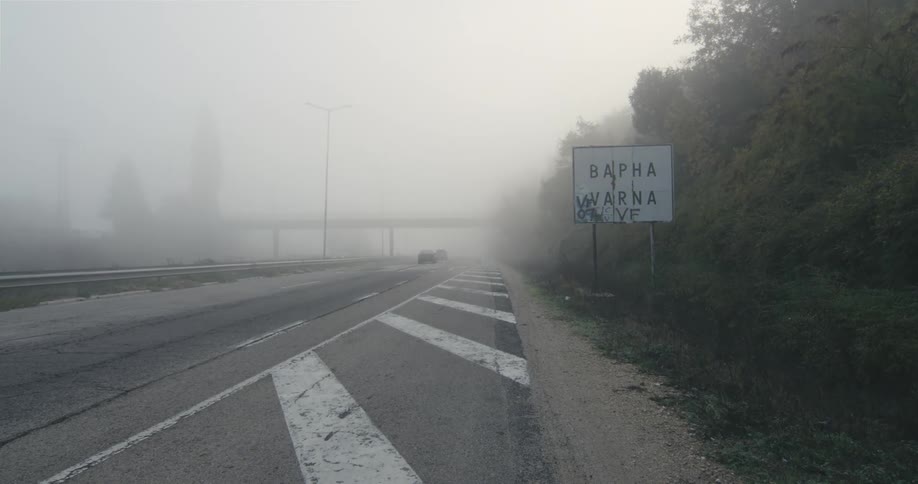 Cars travel on the foggy highway