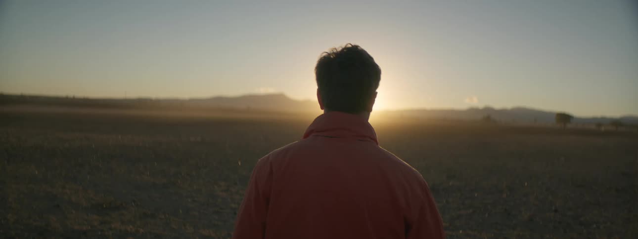 A man is walking in a drought affected barren paddock