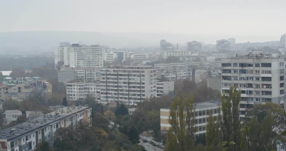 Aerial view of city apartments and houses in smog and fog