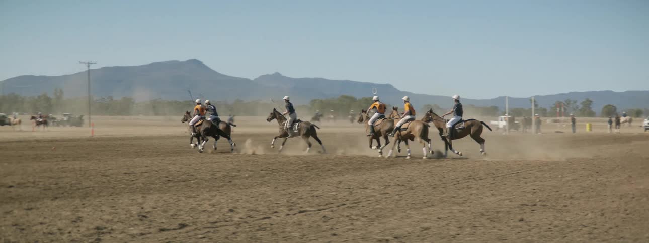 A group of people playing polo on horses outdoors