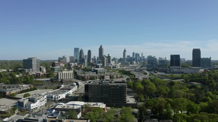Cars travel on city highways with skyscrapers and buildings on the horizon