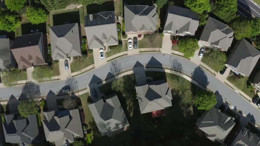 A neighborhood with roads houses vehicles and trees