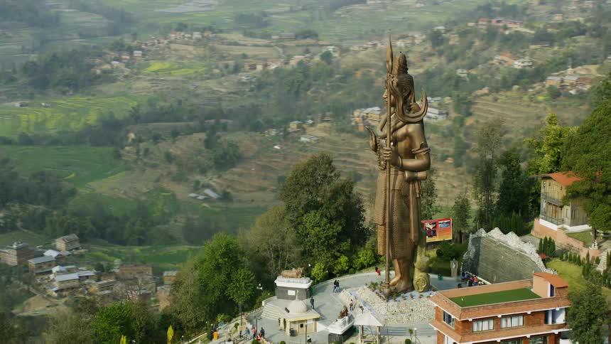 A tall statue sits by the mountain resort
