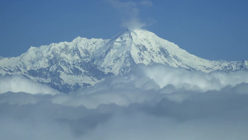 The icy mountain stretches above the clouds