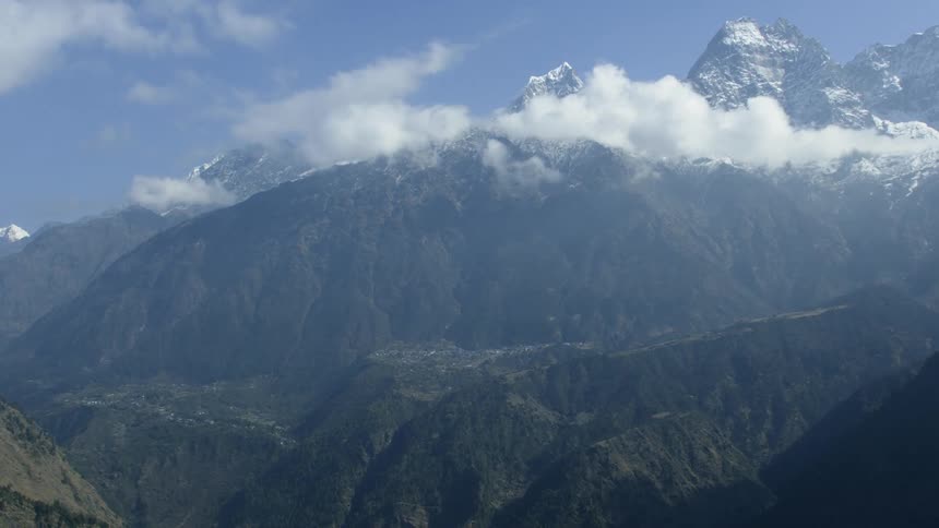 A tall mountain pierces through the clouds