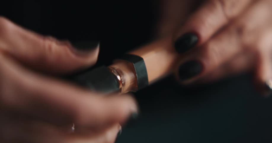 A woman in a room opening a makeup bottle