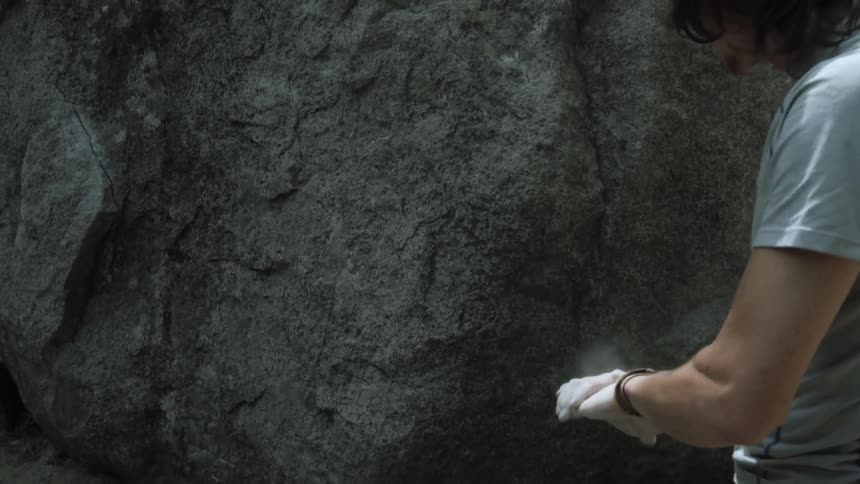 A man claps his hands with powder on him