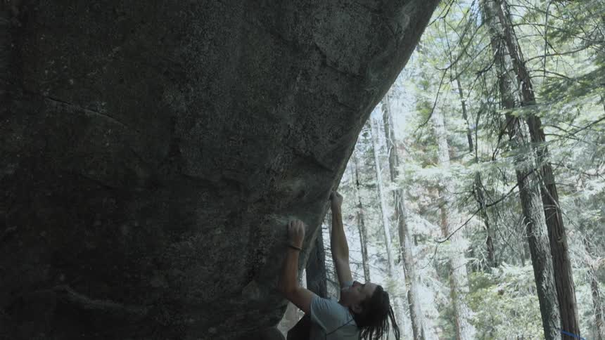 A man tries to climb a low rock