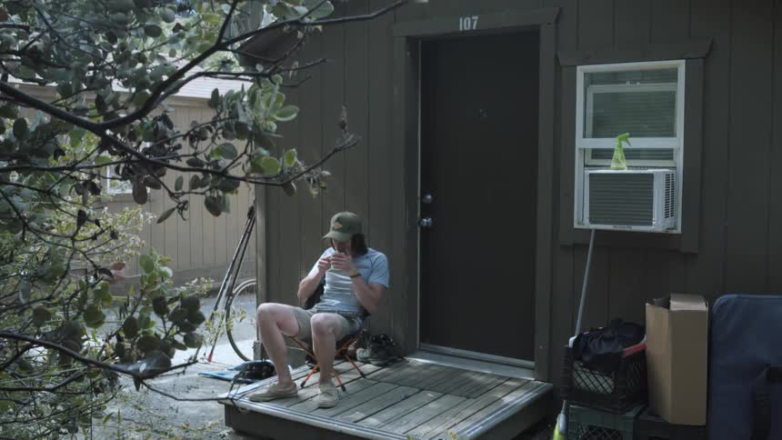 A man is sitting on his porch drinking
