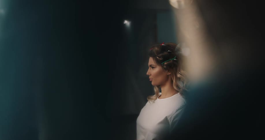 A model examines her hair as her hairdresser stands by