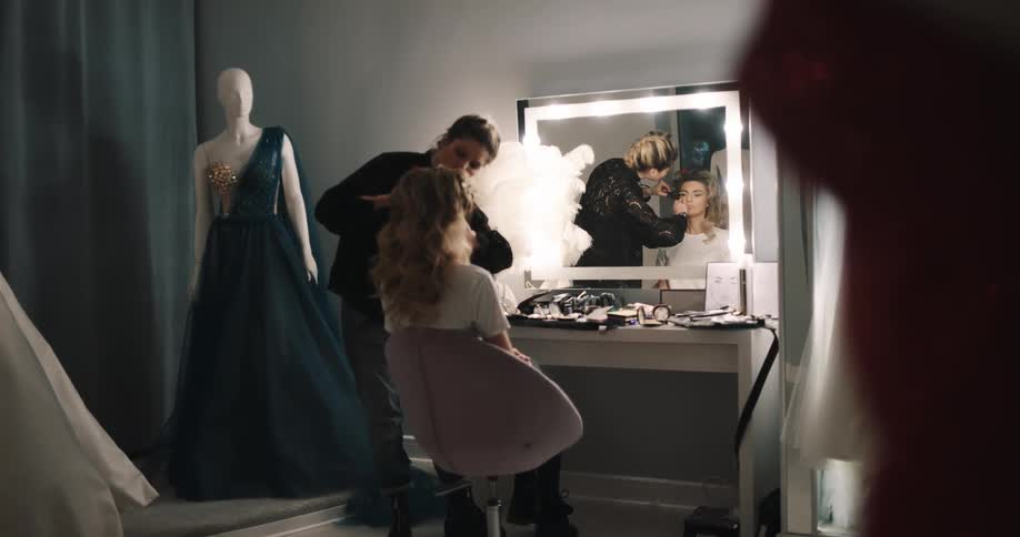 A woman putting makeup onto a model