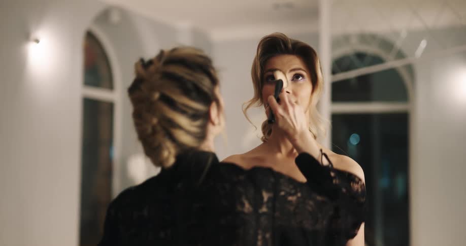 Woman standing with a fancy dress waiting for a stylist to apply makeup
