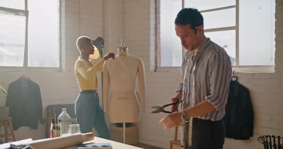 Fashion designers make clothes on mannequin in dressmaker workshop