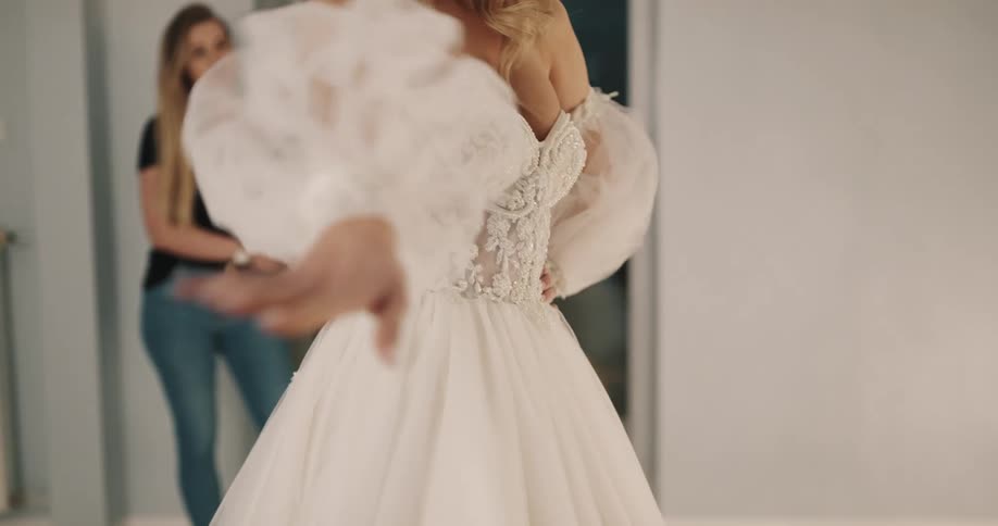 A woman is trying on a wedding dress in a studio at night
